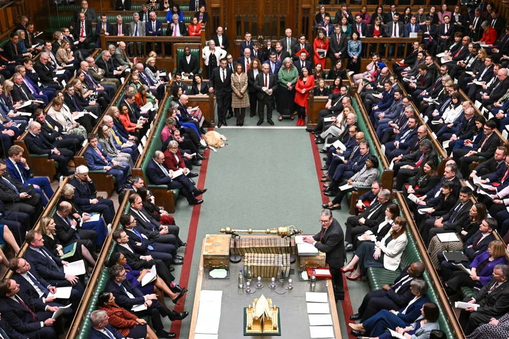 The inside of the house of commons with MPs seated in rows